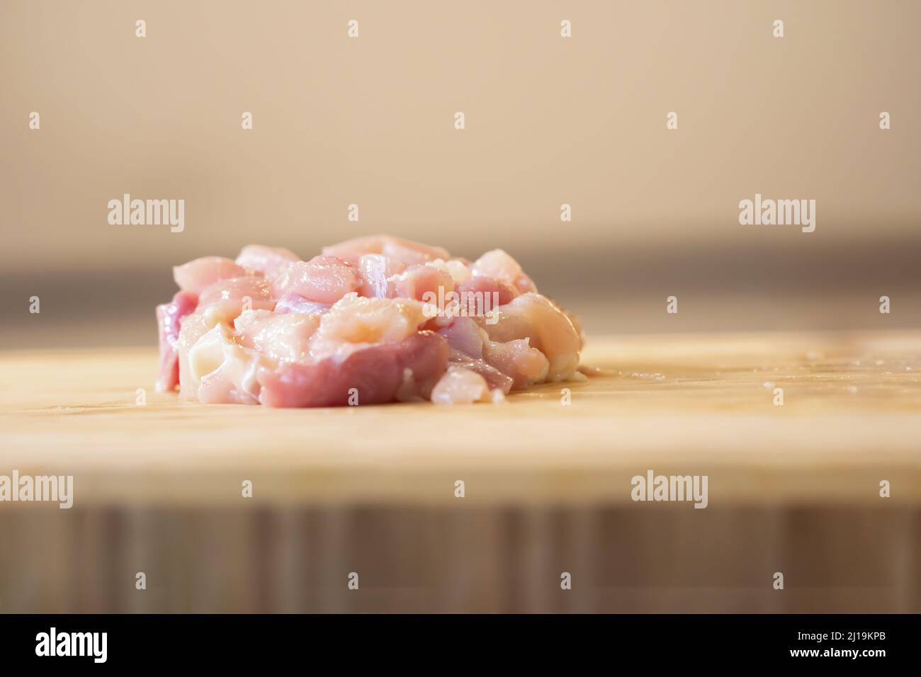 Avvicinati al pollo sminuzzato crudo su un piatto di legno. E' preparato per cucinare il Menu Thai come la zuppa di pollo al latte di cocco. Foto Stock