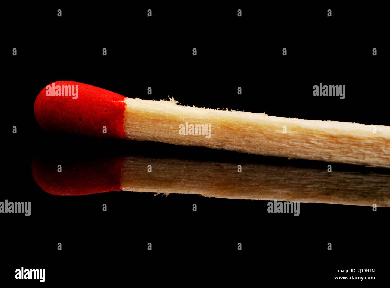 Matchstick singolo con riflessione su sfondo nero Foto Stock