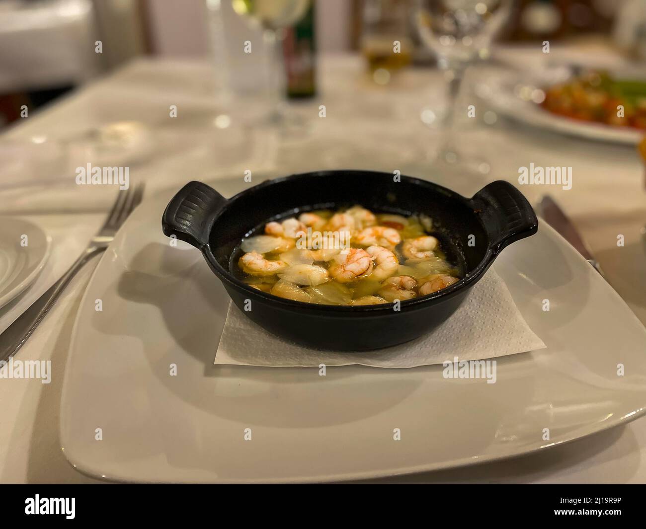 Stirare la padella con olio, aglio e gamberi Foto Stock
