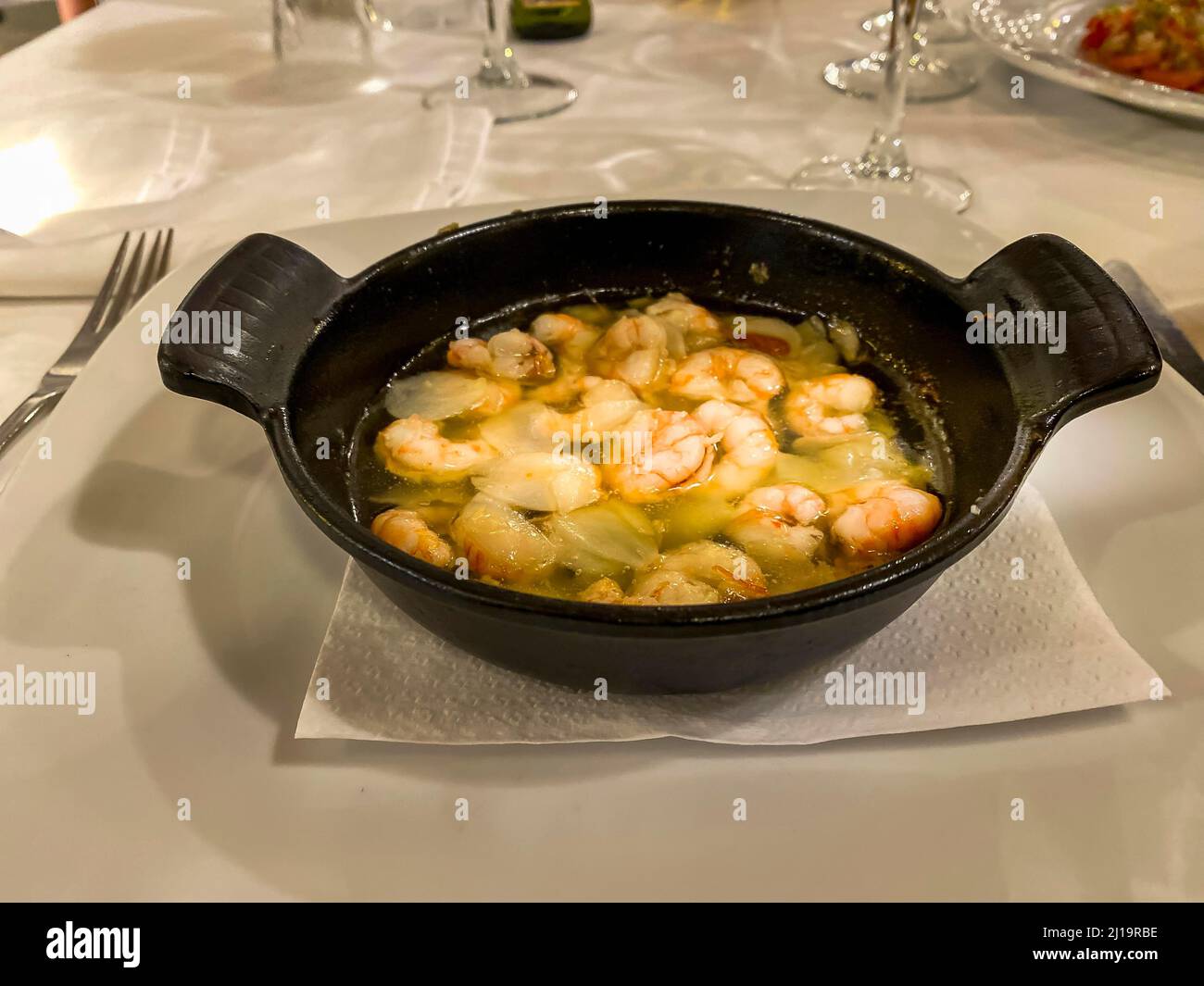 Stirare la padella con olio, aglio e gamberi Foto Stock