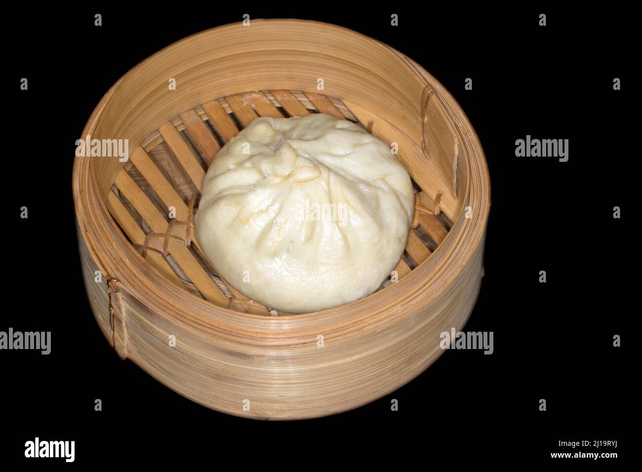 Un bhan al vapore bao, gnocchi di lievito vietnamiti, si trova in un cesto di bambù Foto Stock