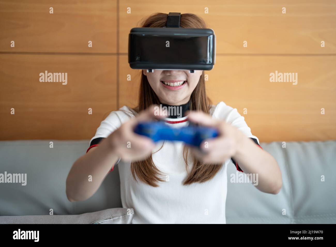 primo piano happy emotion asian donna che gioca videogiochi con controller su sfondo astratto tonato con occhiali virtuali Foto Stock