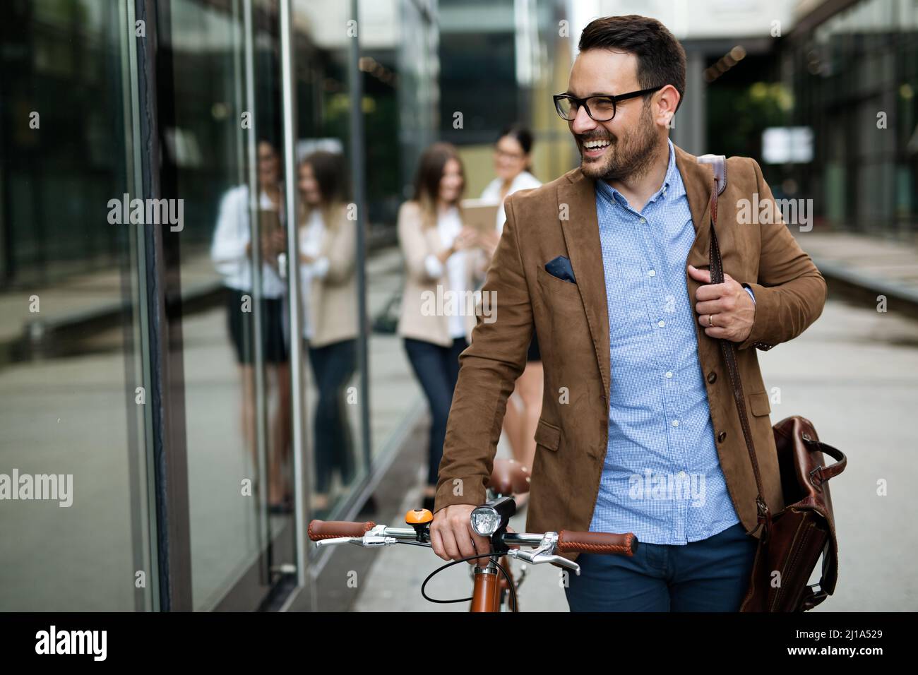 Ritratto di uomo d'affari felice in forma con bicicletta in città moderna all'aperto. Foto Stock