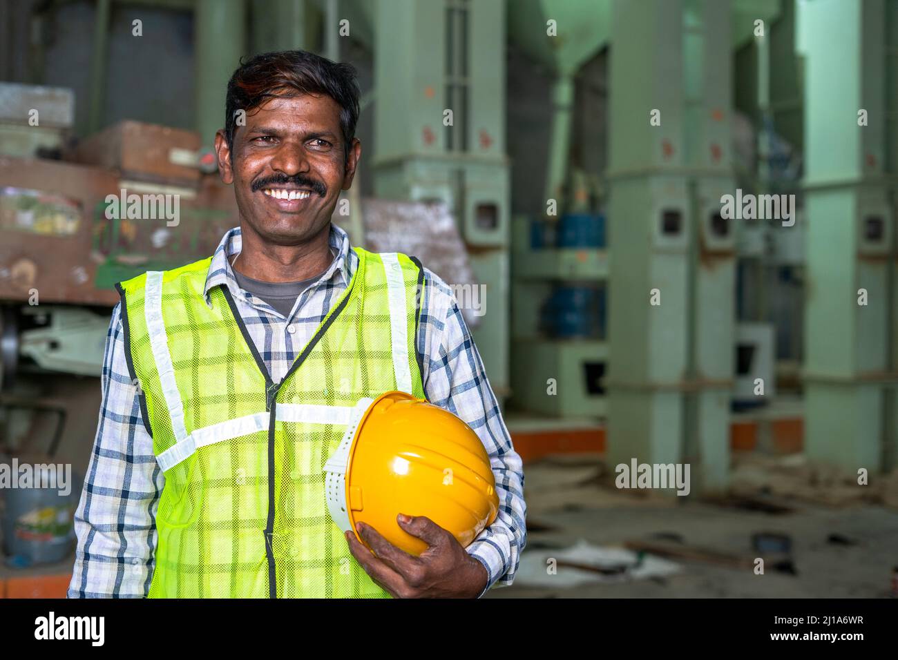 Ritratto di felice sorridente operatrice industriale con casco di sicurezza in mano guardando con spazio copia - concetto di misure di sicurezza, manodopera specializzata e. Foto Stock