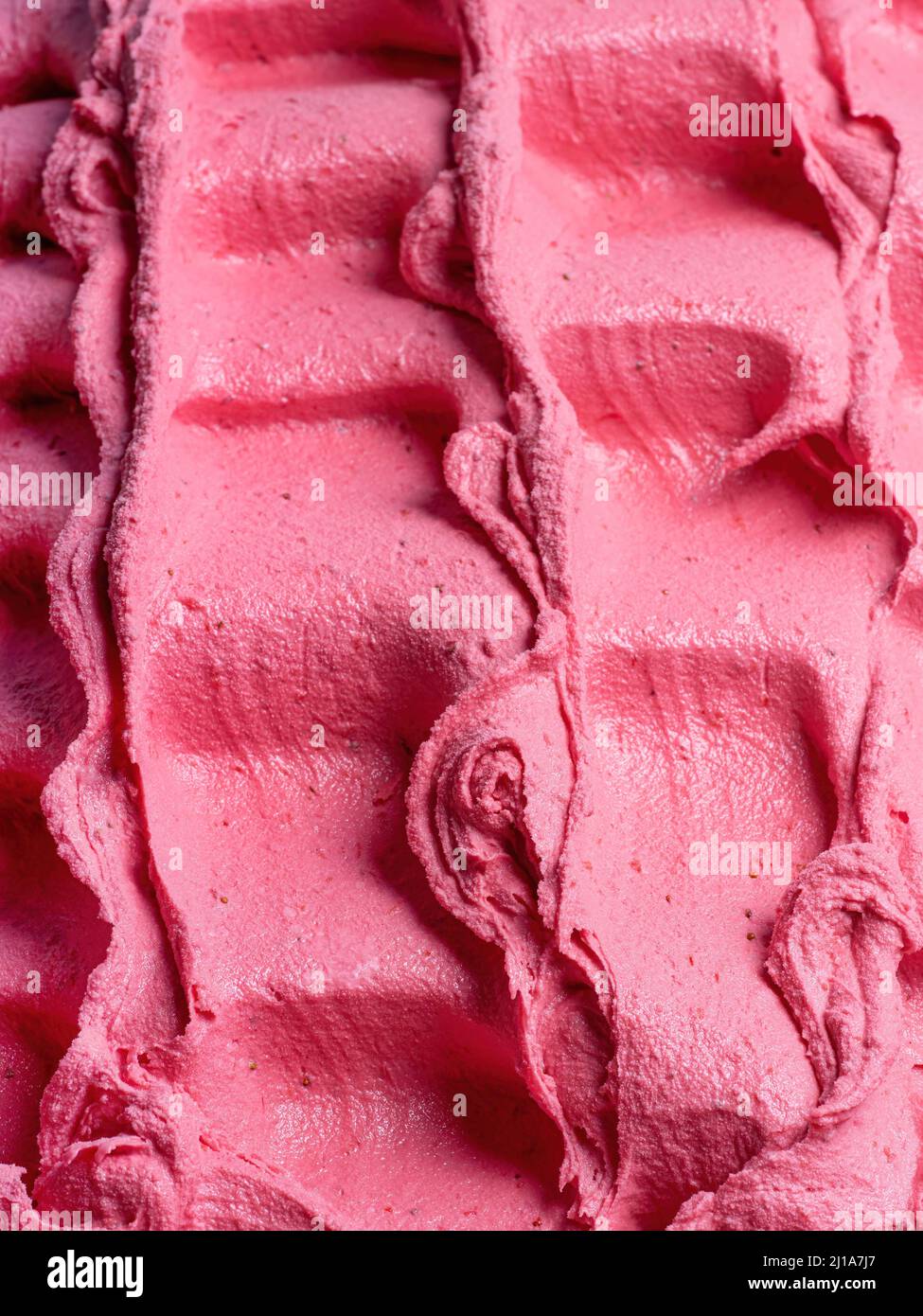 Gelato Frozen Strawberry Flavour - dettaglio telaio completo. Primo piano di una superficie rosa di gelato. Foto Stock