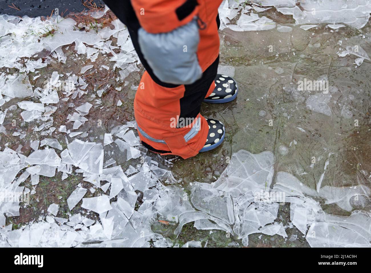 un bambino in tute cammina su ghiaccio sottile Foto Stock