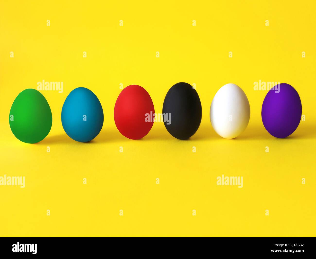 Uova colorate su sfondo giallo. Le vite nere contano, tutte le vite contano, diversità, concetto di pari diritti Foto Stock