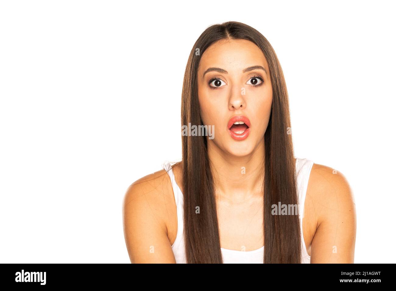 Giovane donna scioccata con bocca aperta su sfondo bianco Foto Stock
