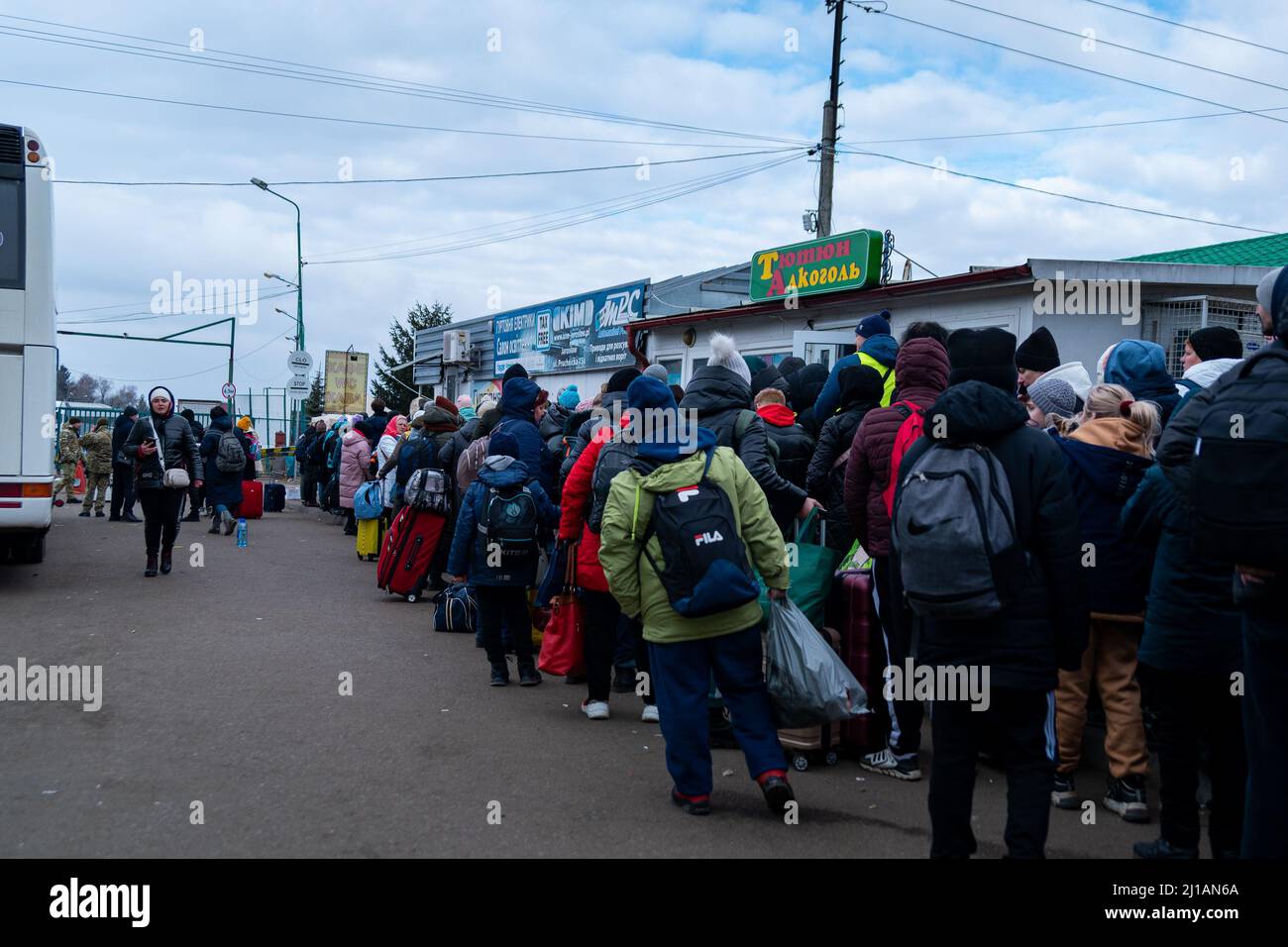 I rifugiati ucraini aspettano in fila mentre attraversano il confine Polonia-Ucraina in fuga dalla guerra Russia-Ucraina a Sheyni, Ucraina, il 8 marzo 2022. Altro Th Foto Stock
