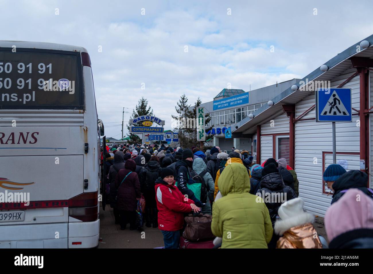 I rifugiati ucraini aspettano in fila mentre attraversano il confine Polonia-Ucraina in fuga dalla guerra Russia-Ucraina a Sheyni, Ucraina, il 8 marzo 2022. Altro Th Foto Stock