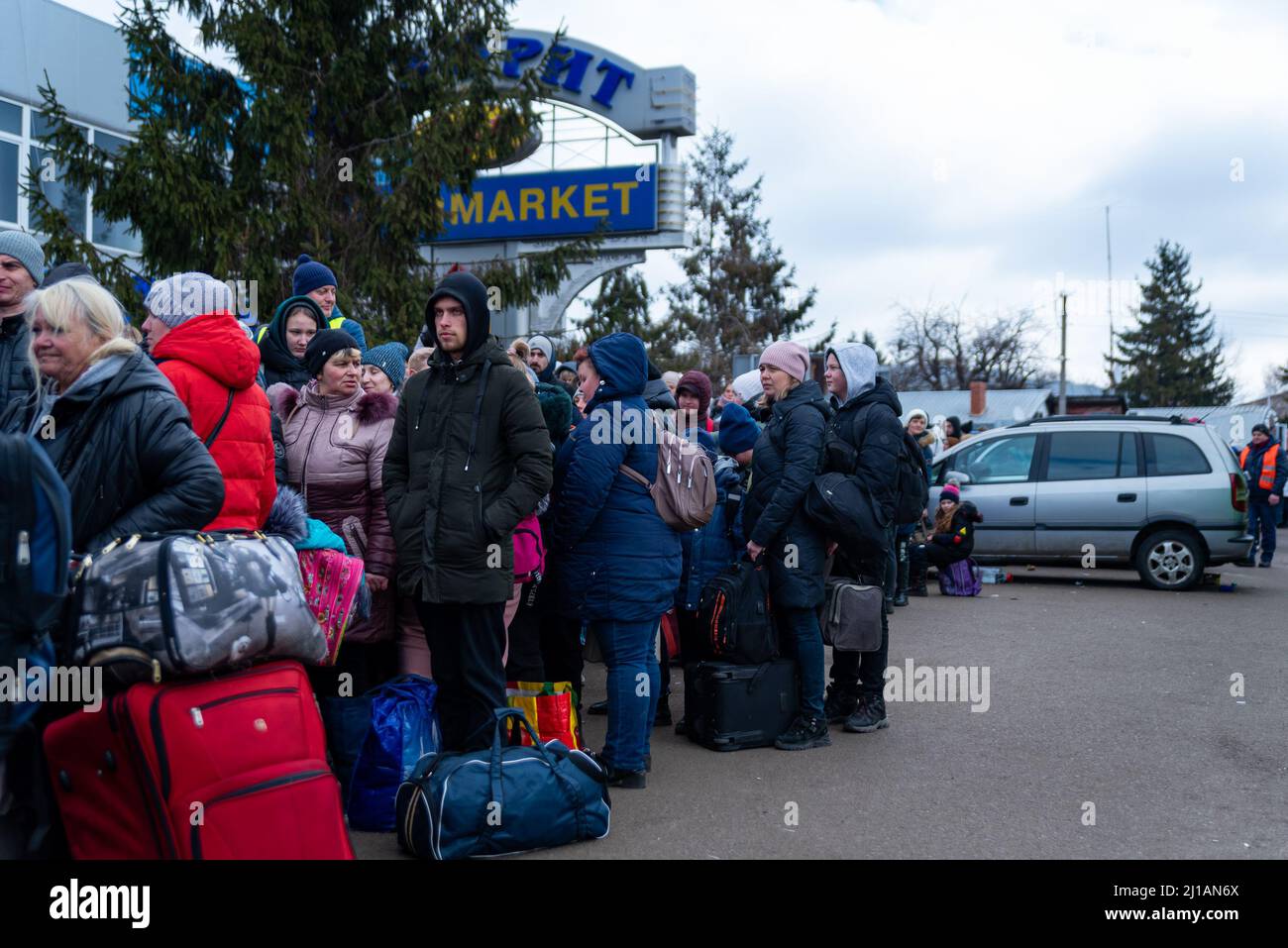 I rifugiati ucraini aspettano in fila mentre attraversano il confine Polonia-Ucraina in fuga dalla guerra Russia-Ucraina a Sheyni, Ucraina, il 8 marzo 2022. Altro Th Foto Stock