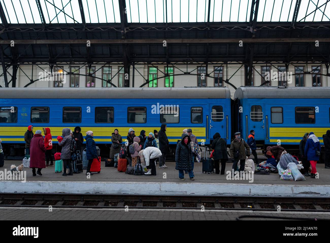 I rifugiati con bagagli e valigie sono visti su una piattaforma della stazione ferroviaria di Lviv-Holovnyi in attesa di salire a bordo di un treno per fuggire dal paese a LVI Foto Stock