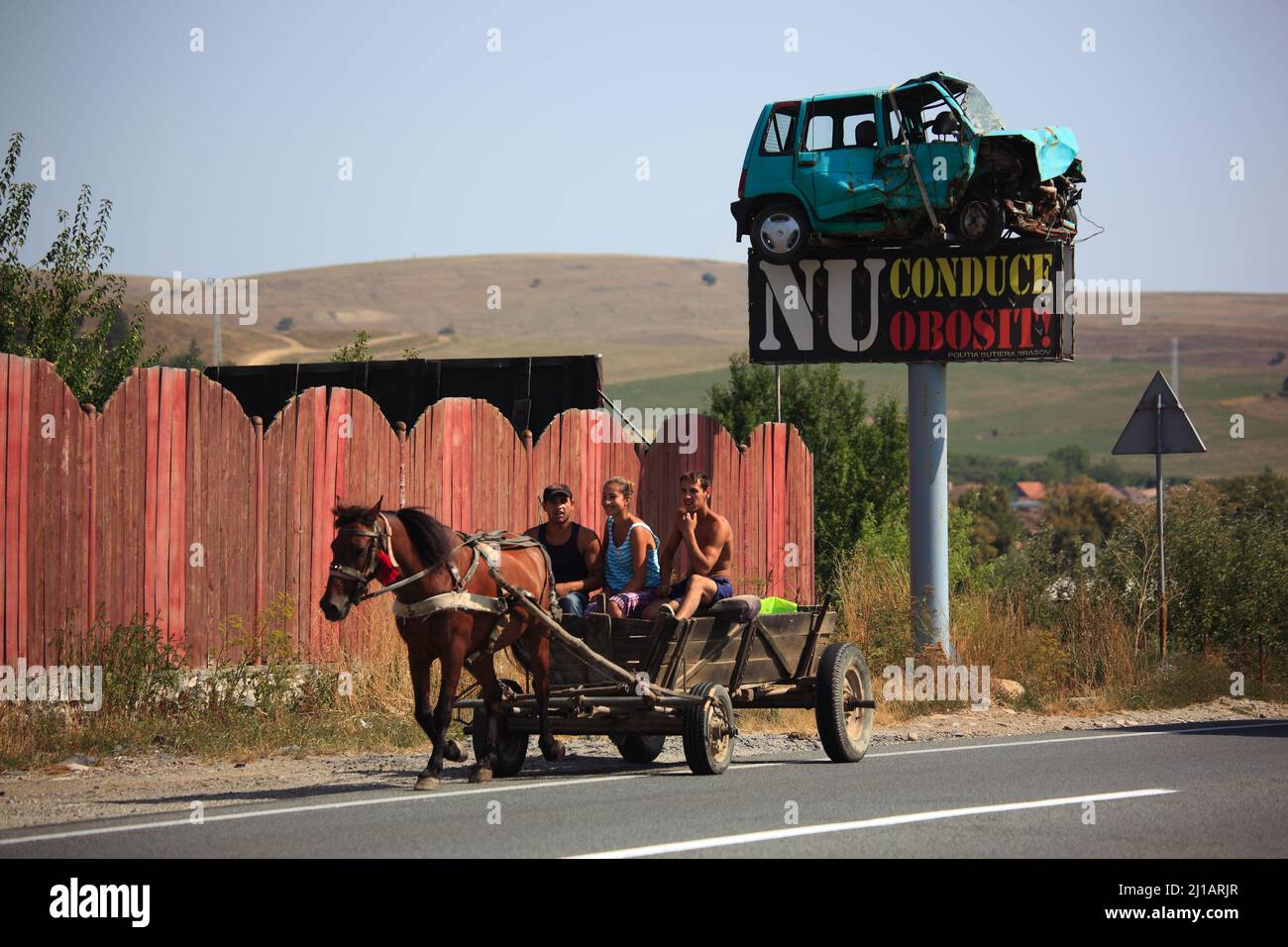 Straßenverkehr in Siebenbürgen, Rumänien, als Warnung wurde ein Unfallwagen als Verkehrsschild montiert, Pferdegespann auf der Straße / traffico stradale Foto Stock