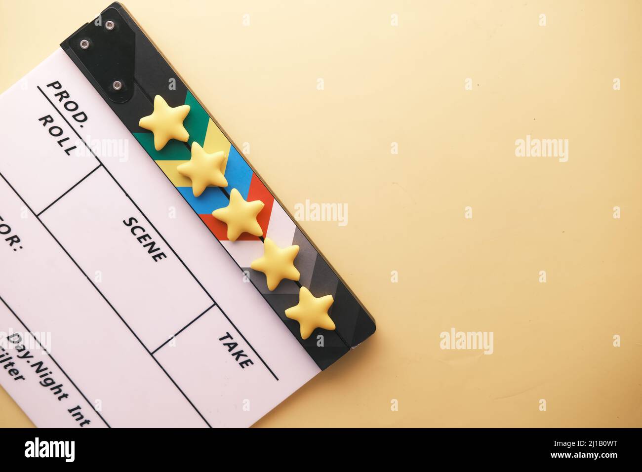 Stelle dorate e scheda clapper film su sfondo a colori Foto Stock