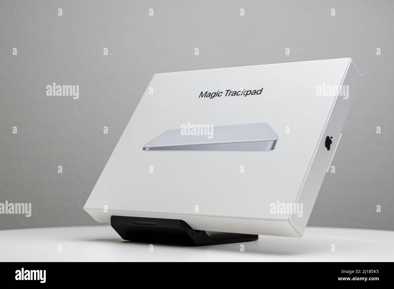 Confezione bianca inclinata del Magic trackpad Mac Apple sul supporto dello schermo. Foto Stock