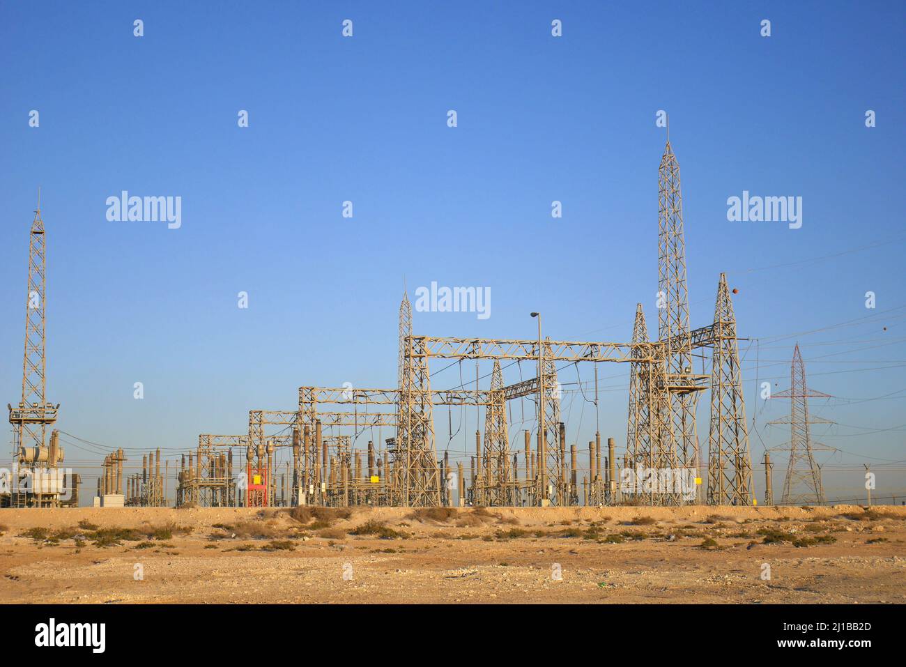 Paesaggio industriale del deserto con piloni elettrici, Governatorato del Sud, Regno del Bahrain Foto Stock