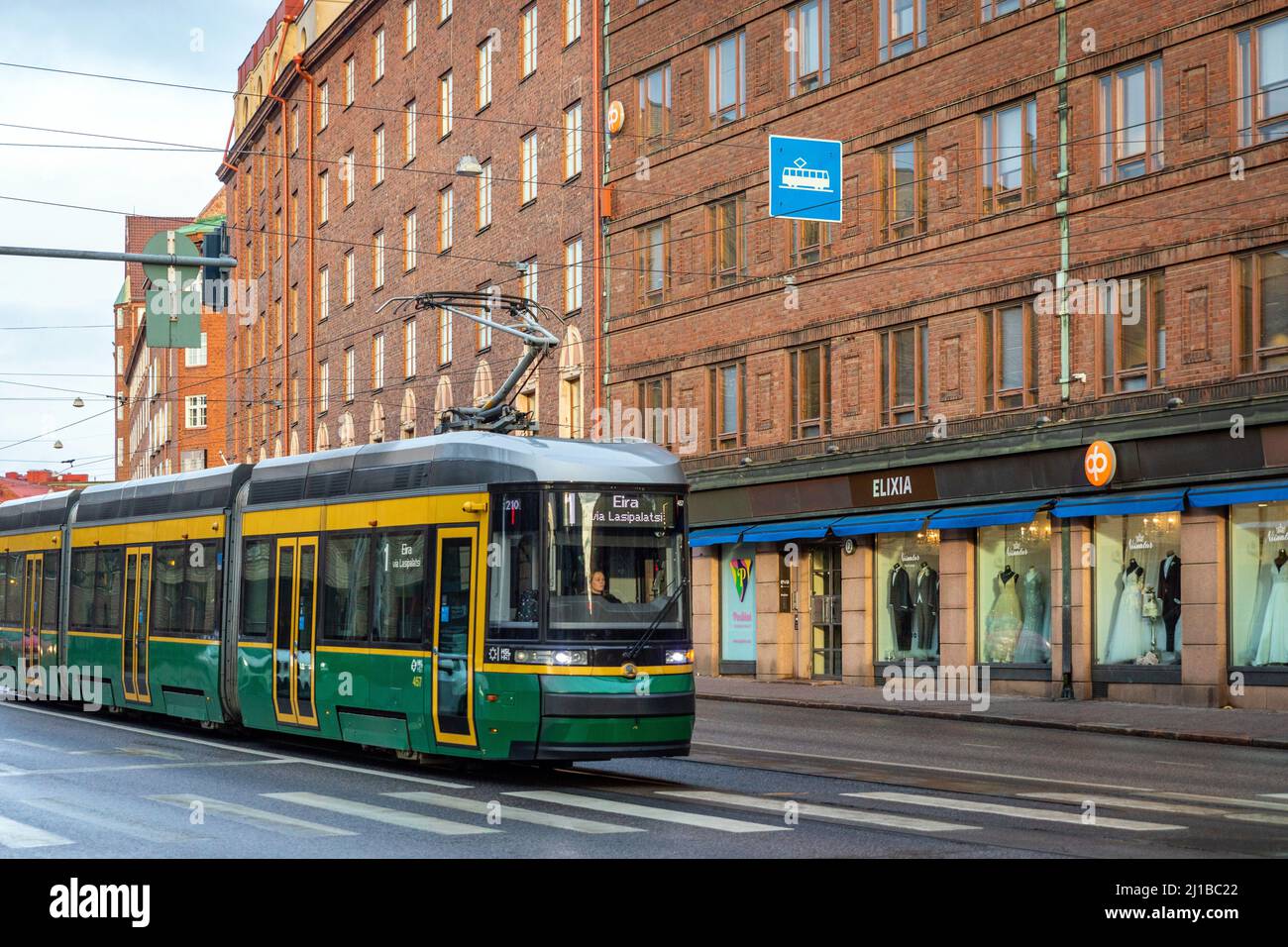 TRAM DI FRONTE AGLI EDIFICI IN MATTONI ROSSI TIPICI DELL'ARCHITETTURA FINLANDESE, HELSINKI, FINLANDIA, EUROPA Foto Stock