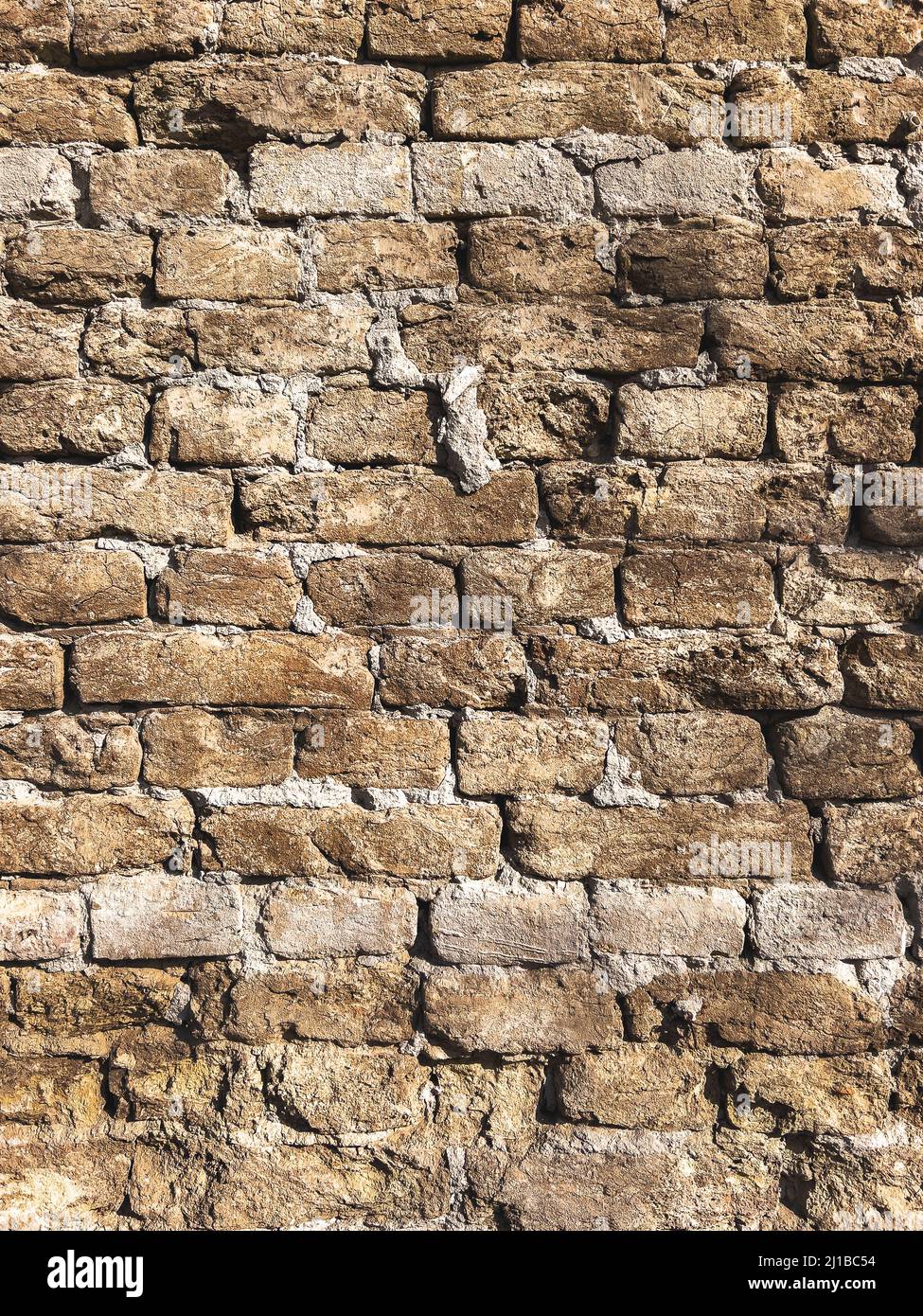 Superficie di una vecchia parete di mattone come sfondo, immagine verticale di mattoni logorati modello Foto Stock