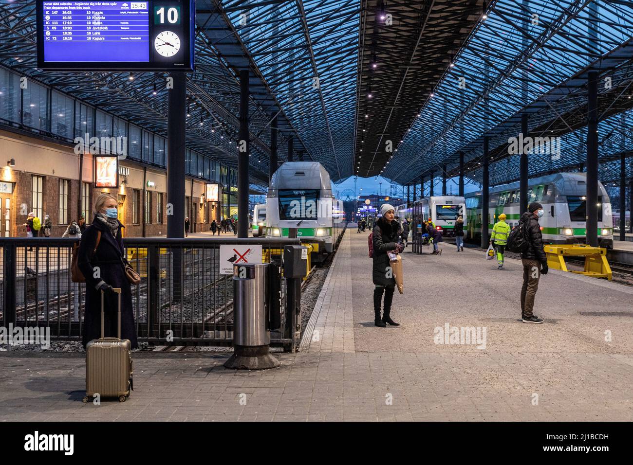 TRENI ALLA PIATTAFORMA NELLA STAZIONE FERROVIARIA PRINCIPALE AL NIGHTFALL, HELSINKI, FINLANDIA, EUROPA Foto Stock
