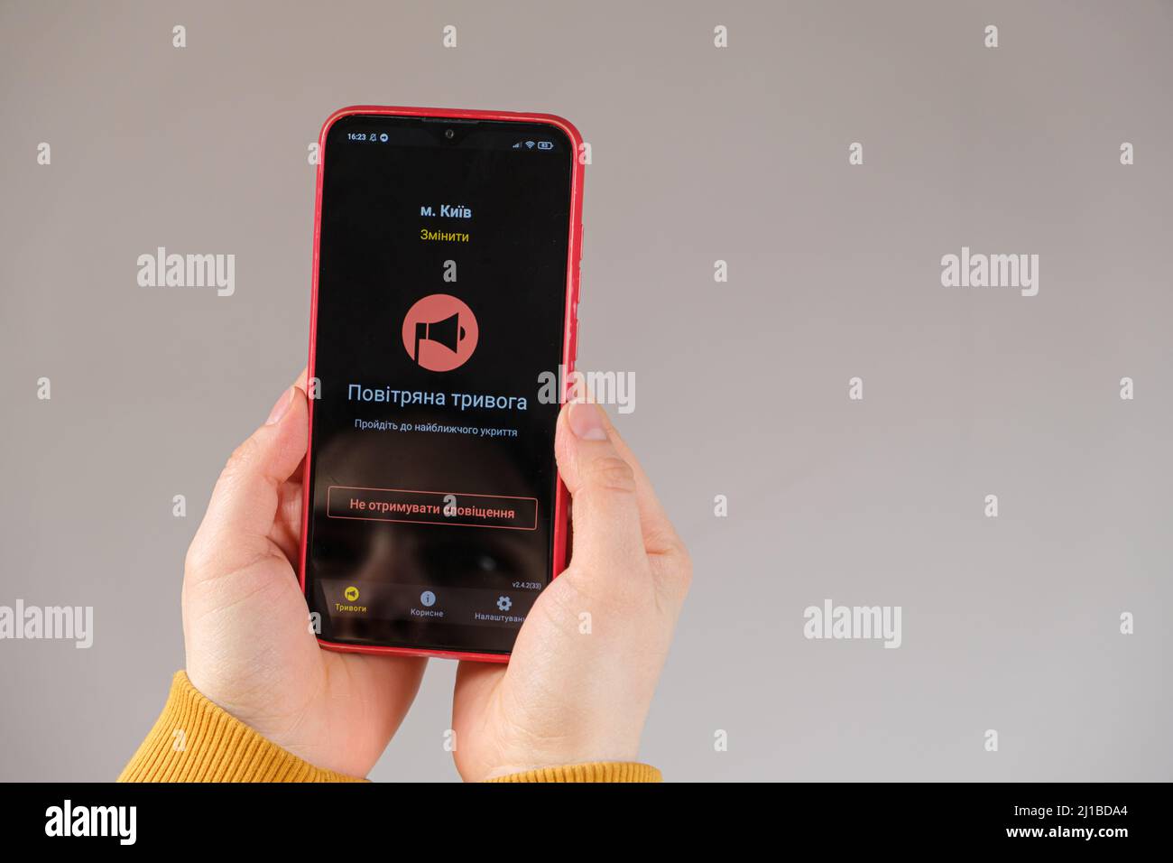 21 marzo 2022, Kiev, Ucraina. Uno smartphone nelle mani di una persona con l'app di avviso pericolo attivata. Tradotto da ucraino - allarme aereo. Foto Stock