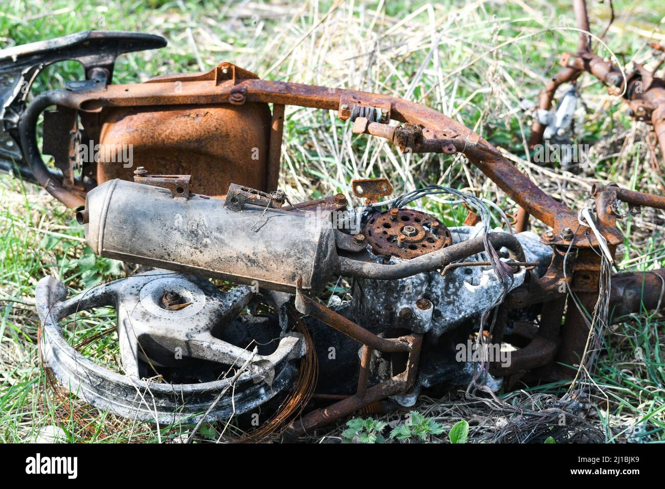 ciclomotore bruciato scaricato in un campo Foto Stock