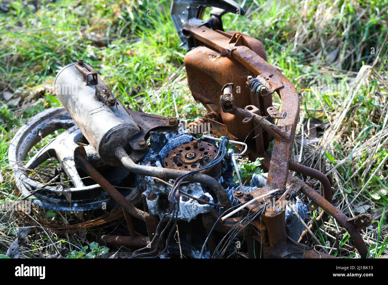 ciclomotore bruciato scaricato in un campo Foto Stock