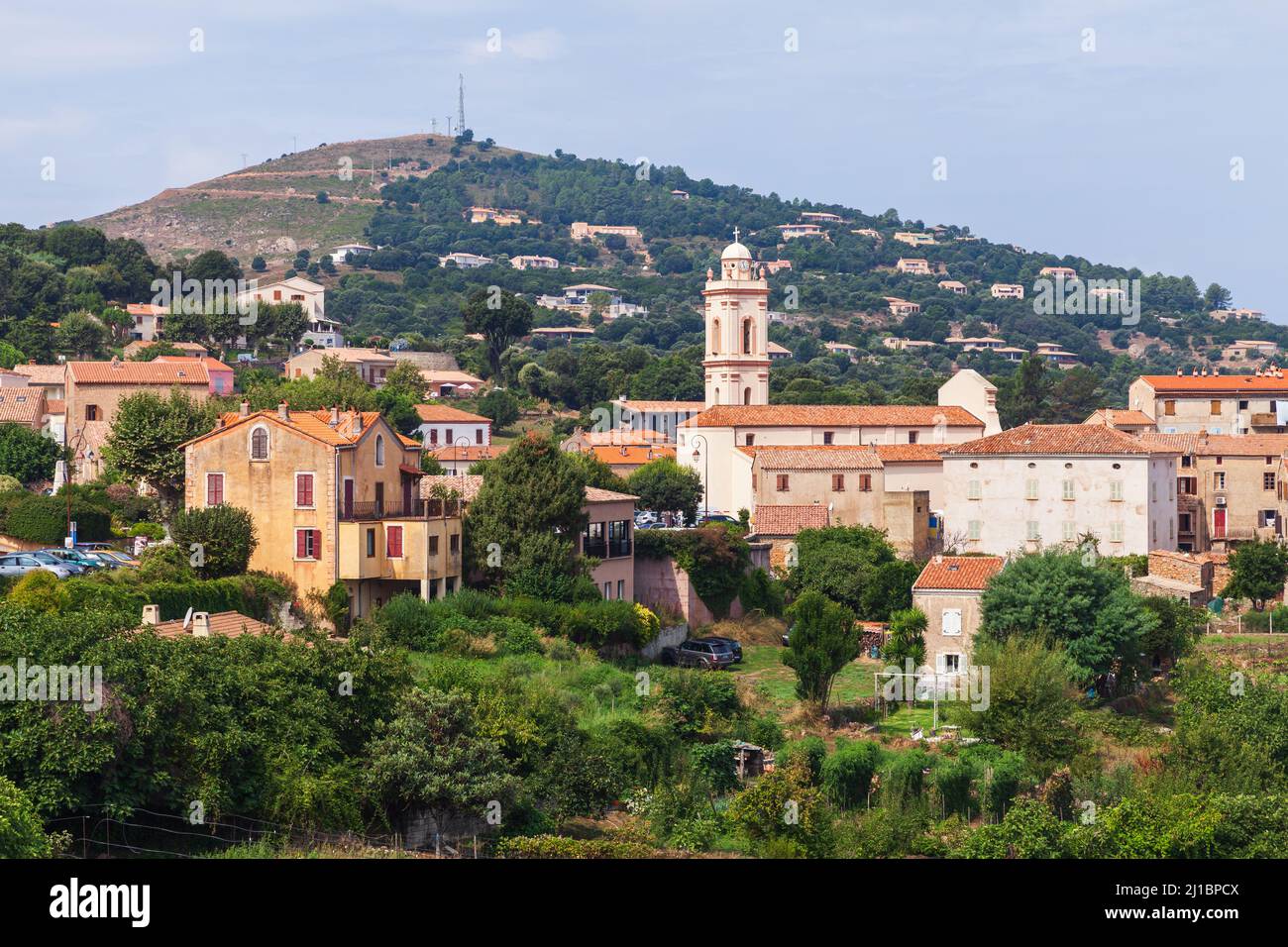 Piana, Corsica del Sud, Francia. Vista sulla città corsa, vecchie case in pietra con tetti di tegole rosse con montagne su sfondo Foto Stock