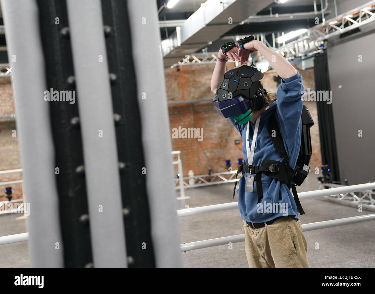 24 marzo 2022, Amburgo: Un visitatore si alza con zaino e casco, così come sensori per mani e piedi e tracker nella nuova attrazione di realtà virtuale 'Yullbe' (abbreviazione per voi sarà) in Miniatur Wunderland. Da aprile 1, i visitatori di 'Yullbe Wunderland' potranno intraprendere un tour virtuale del mondo dell'avventura in miniatura, come minuscoli personaggi digitali. Con occhiali per realtà virtuale o un casco corrispondente sulla testa, diventerai un abitante del Miniatur Wunderland nel mondo dello Yullbe e potrai scoprire il selvaggio West, Venezia o altri mondi praticamente con i tuoi occhi, mani e piedi. P Foto Stock