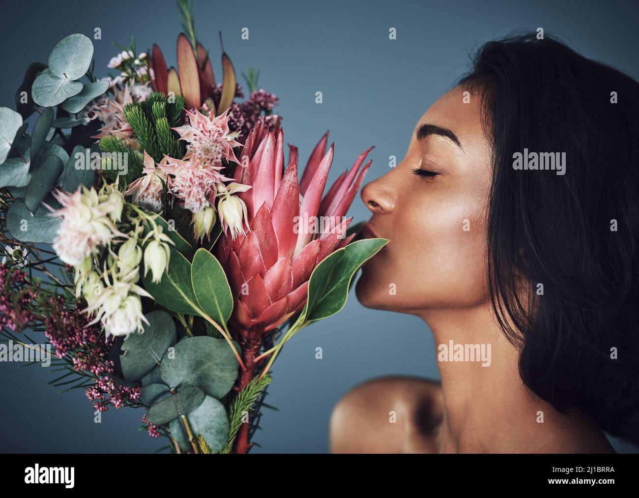 I fiori riflettono chi siamo. Scatto corto di una bella giovane donna che puzzava un bouquet di fiori. Foto Stock