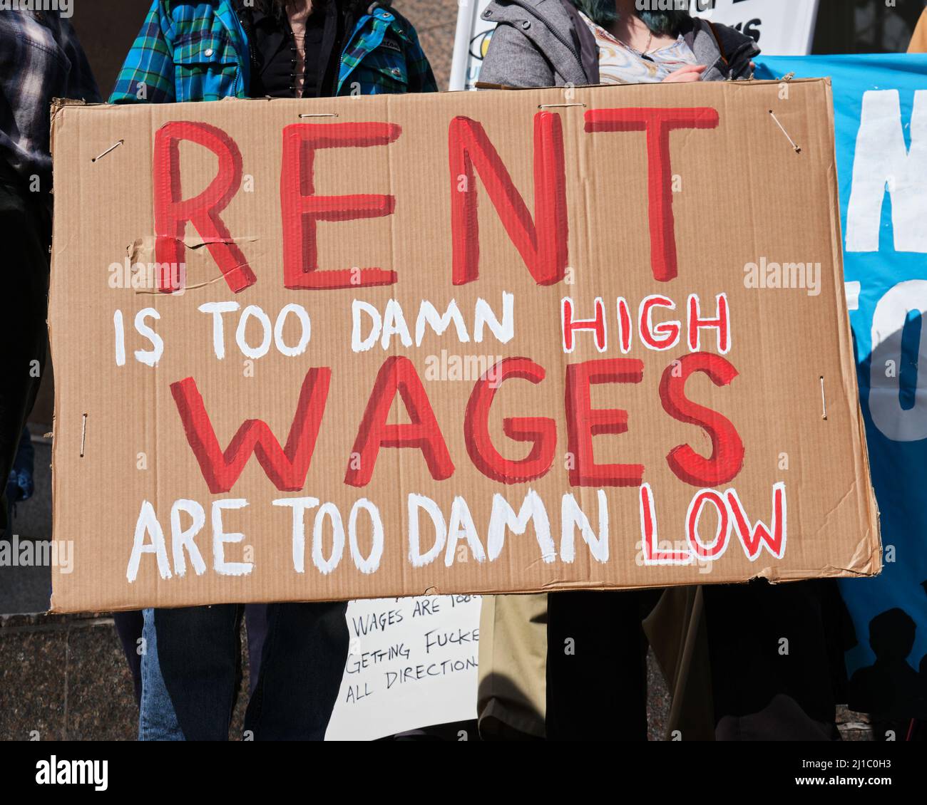 L'affitto è troppo alto, i salari sono troppo basso segno al raduno contro la povertà a Halifax, canada Foto Stock
