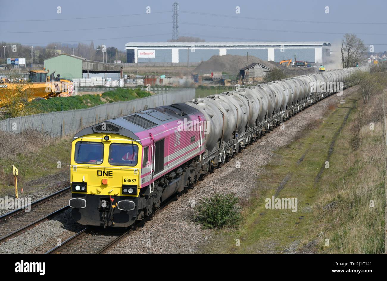 Unica locomotiva diesel elettrica classe 66 66587 "come unica, possiamo" trasportare tramogge di cemento da Hope Earles Sidings a Walsall Terminal Foto Stock