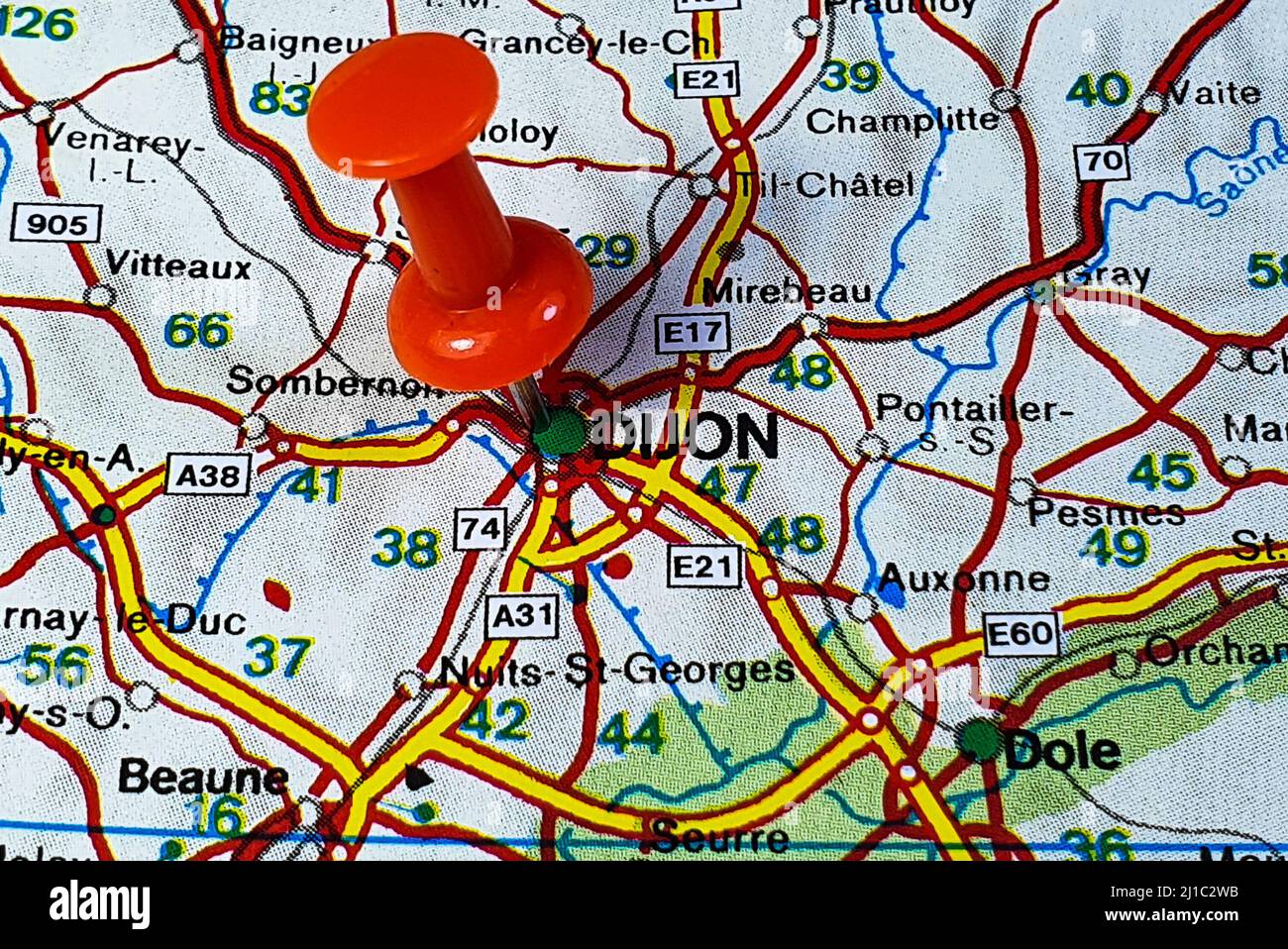 Primo piano di una puntina rossa che segna la posizione di Digione, Francia su una mappa astratta e colorata Foto Stock