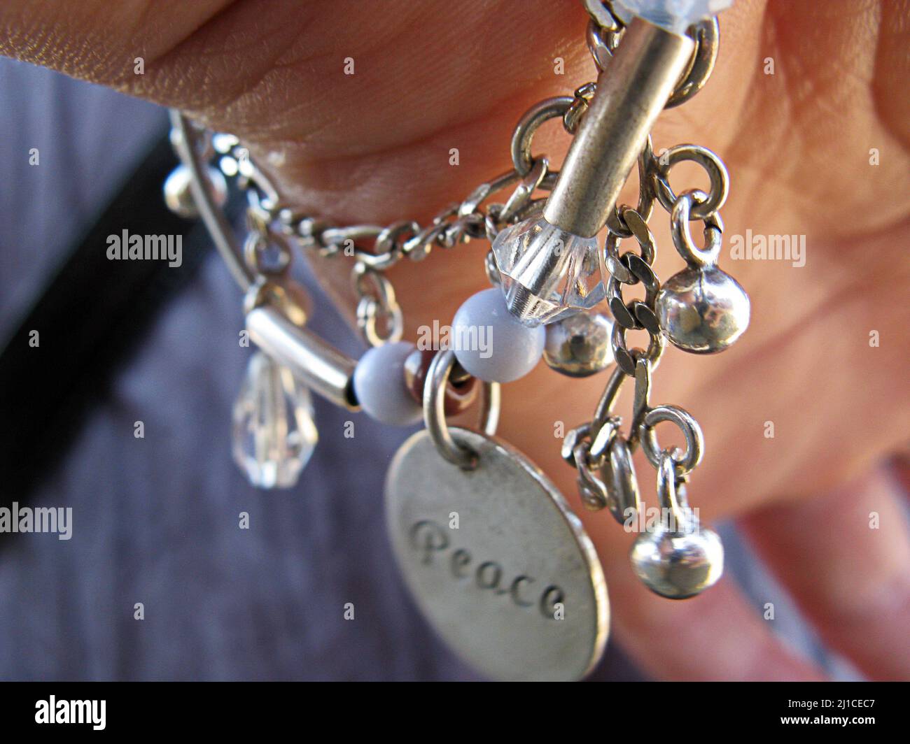 Eleganti braccialetti in argento a mano della ragazza. La parola Pace è  scritta sul braccialetto. Primo piano. Messa a fuoco selettiva Foto stock -  Alamy