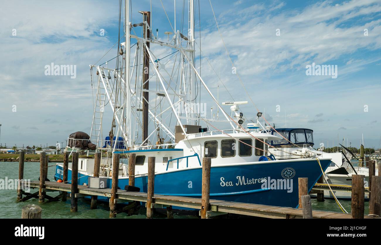 ROCKPORT, TX - 3 FEB 2020: Gamberetto commerciale bianco e blu legato con corda al molo di legno in un porticciolo. Foto Stock