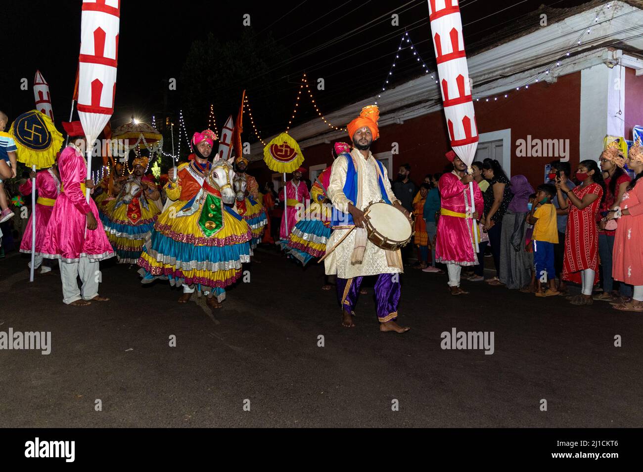 Gruppo di uomini vestiti da soldati montati a cavallo, in abiti colorati, eseguono la famosa danza Ghode Modni alla parata Shigmo a Ponda, Goa Foto Stock