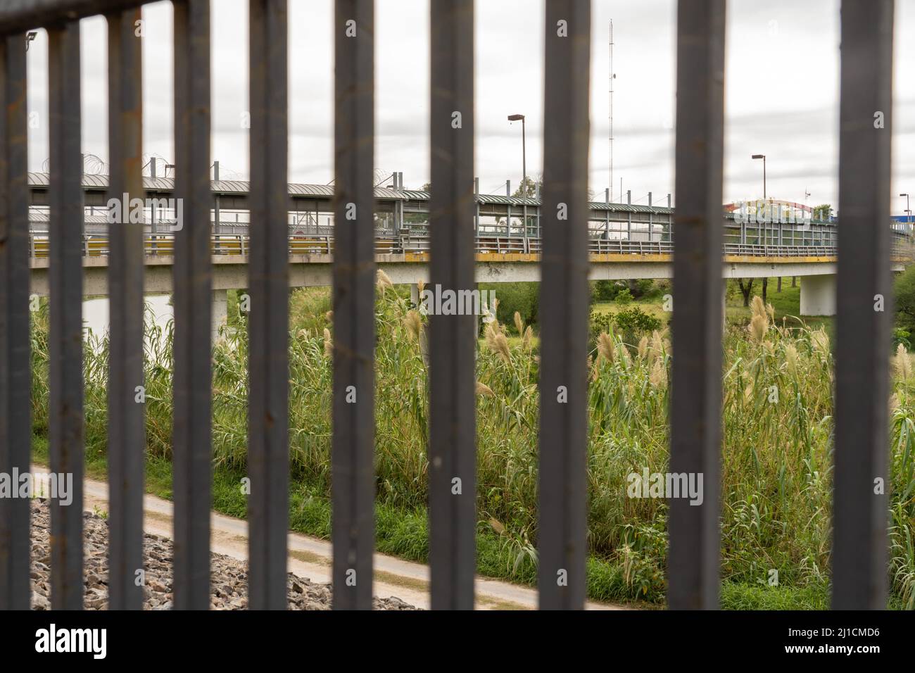 Il Gateway International Bridge tra Brownsville, Texas e Matamoros, Messico, visto attraverso il muro di confine. Vista dal lato del Texas del wal Foto Stock