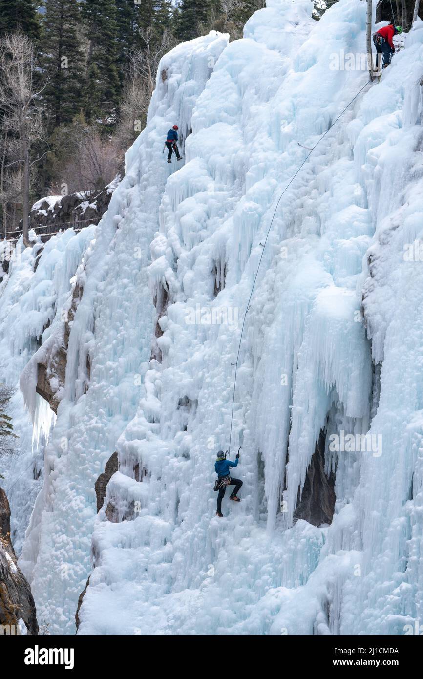 Un arrampicatore a destra sale come un altro arrampicatore a sinistra si arrampica su una parete di ghiaccio alta 160' nel Parco di ghiaccio di Ouray, Colorado. Foto Stock