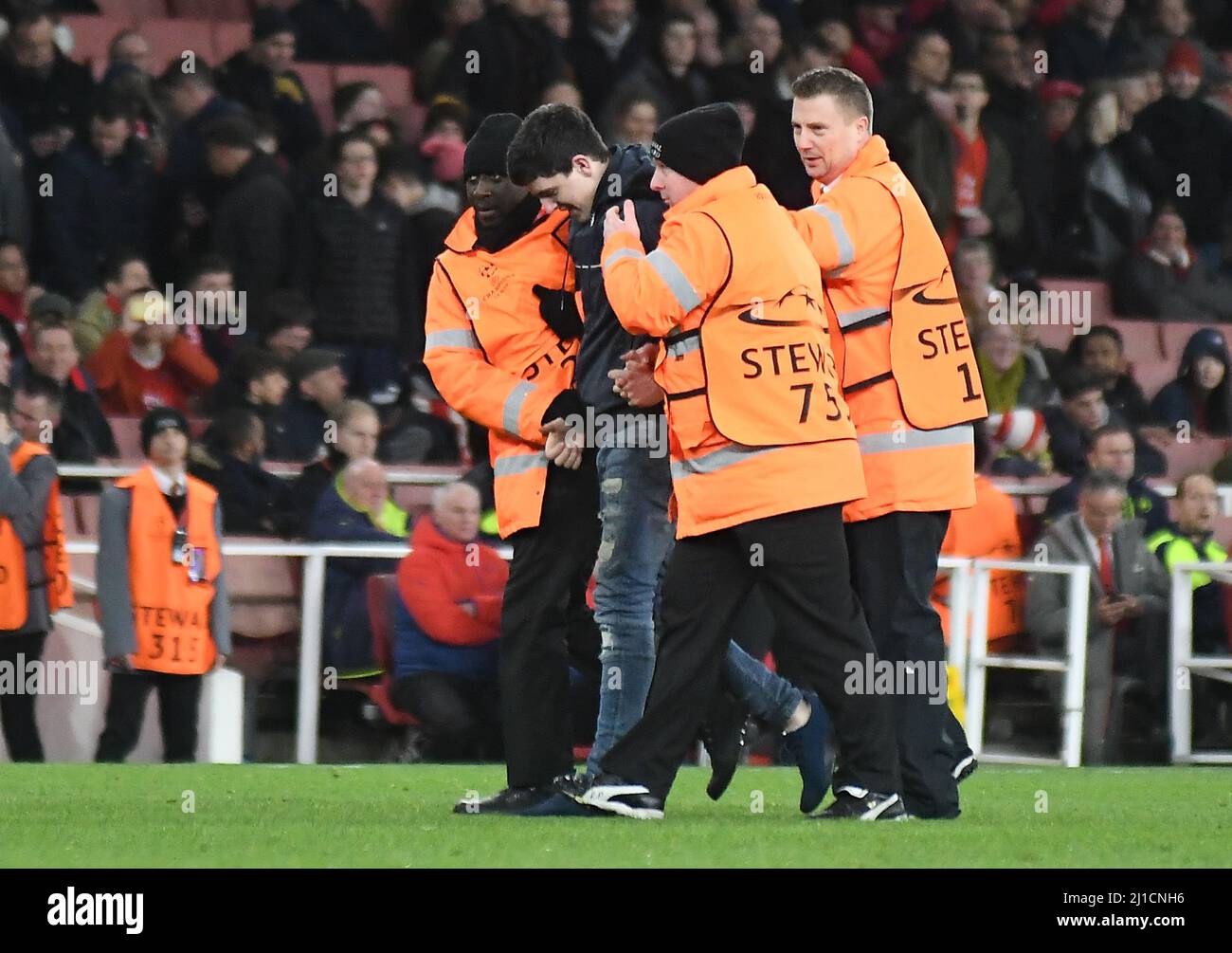 LONDRA, INGHILTERRA - 7 MARZO 2017: Steward eseguire un fan che ha invaso il campo alla fine della seconda tappa della UEFA Champions League Round del 16 tra l'Arsenal FC e il Bayern Munchen all'Emirates Stadium. Copyright: Cosmin Iftode/Picstaff Foto Stock
