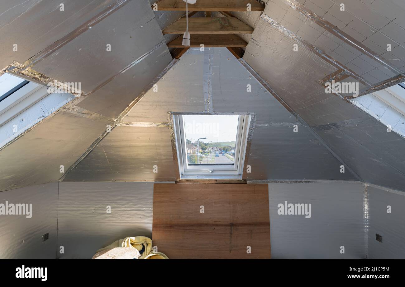 Conversione di loft residenziale senza finitura con isolamento in argento Foto Stock