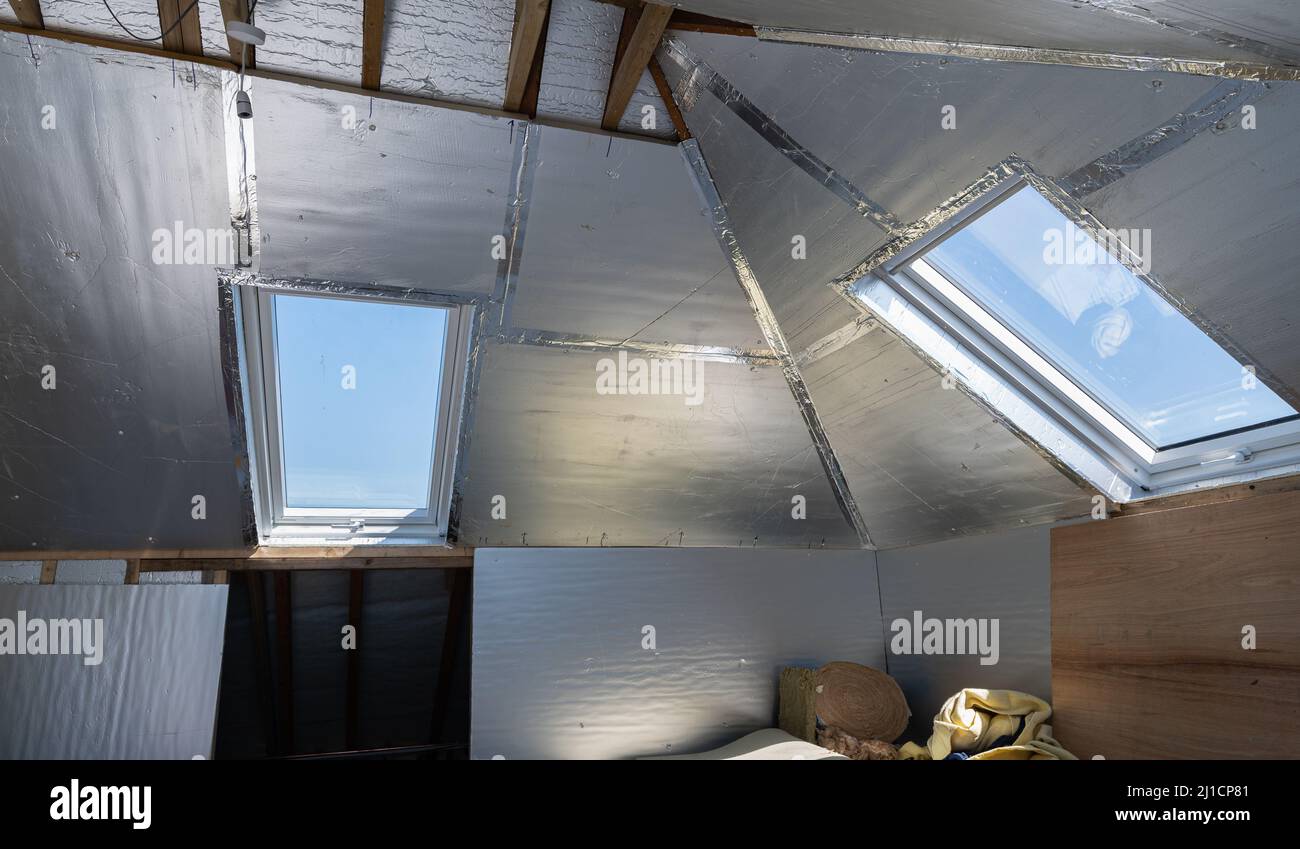 Conversione di loft residenziale senza finitura con isolamento in argento Foto Stock