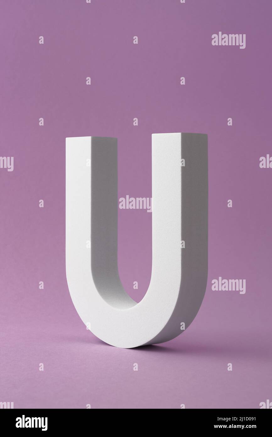 Scatto verticale di un oggetto a forma di lettera U su sfondo viola Foto Stock
