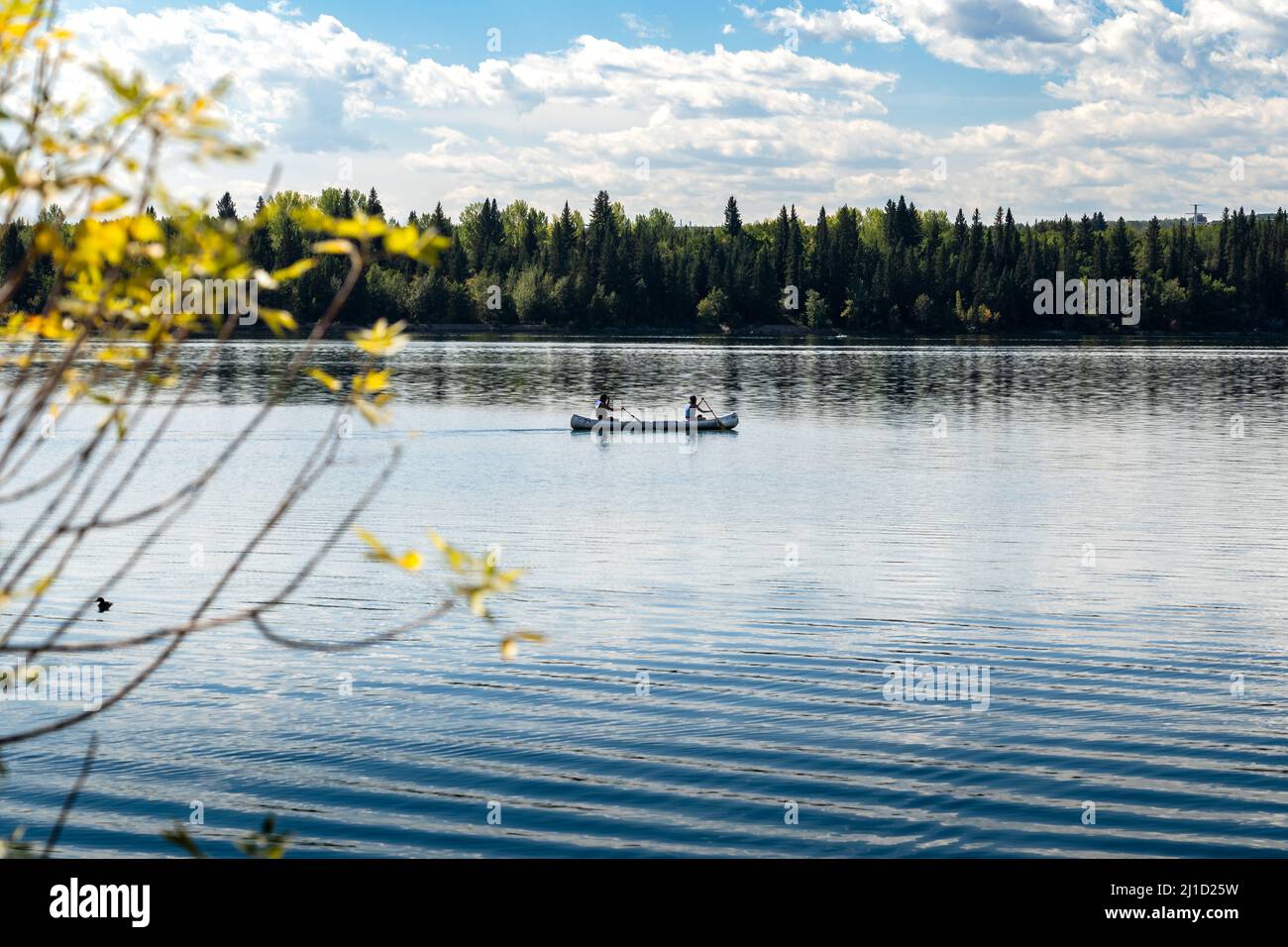 Due persone pagaiano una canoa sul lago artificiale Glenmore in una luminosa giornata primaverile a Calgary, Alberta, Canada. Foto Stock