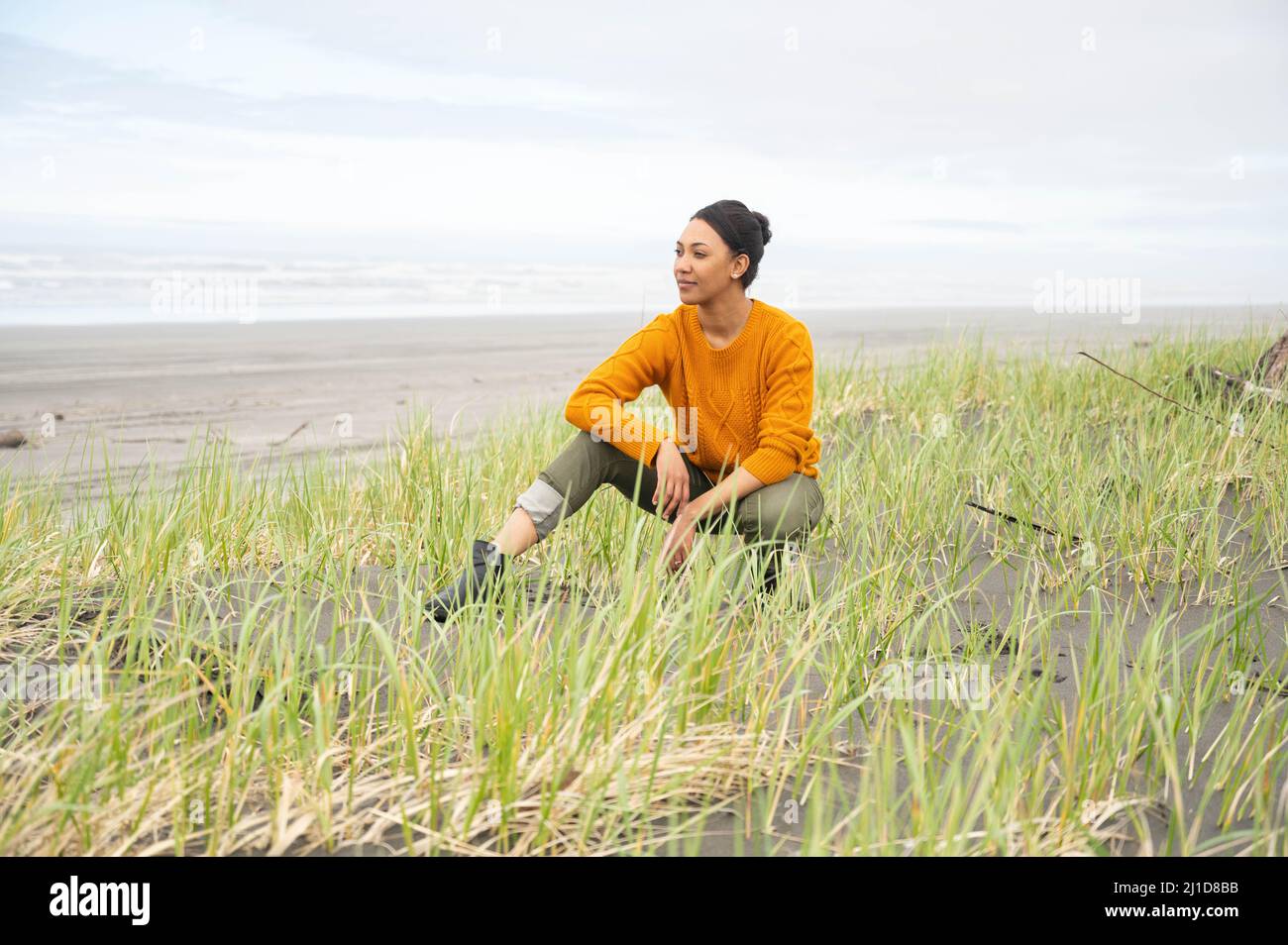 Donna nera alla spiaggia nuvolosa del Pacifico nord-occidentale Foto Stock