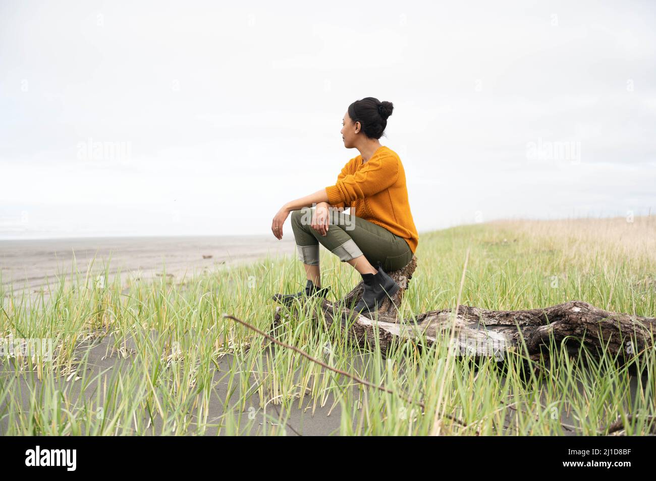 Donna nera alla spiaggia nuvolosa del Pacifico nord-occidentale Foto Stock