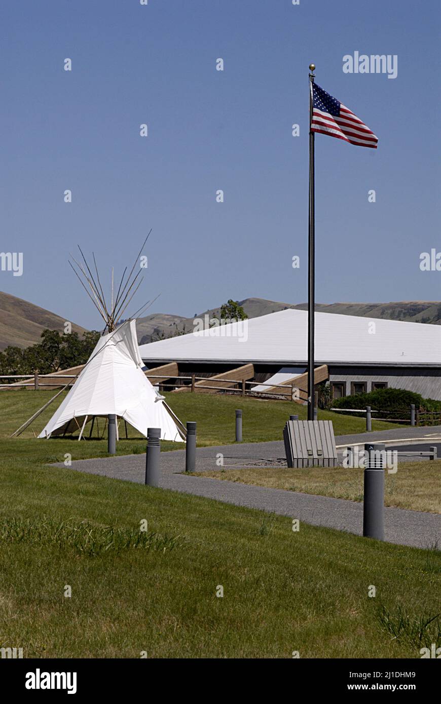 SPALDING / IDAHO STATE/ USA . Bandiera degli Stati Uniti e Tepe Indiano al Nez Perce Musuem, il sito di Spalding, situato lungo l'autostrada US 95 fino alla sede del Nez Perce National Historical Park, Un moderno centro visitatori offre una bella collezione di film museo sulla storia del popolo Nez Perce e un piccolo negozio di articoli da regalo. Il sito di 99 ettari contiene cimiteri storici e l'edificio, cartelli interpretativi e grande area picnic, l'attuale communit e parco di spalding ufficiale chiamato nel 1897 è stato Originariamente chiamato Lapwai e servito come homesite tradizionale per oltre 11.000 anni al thlep-thlep weyma band Foto Stock