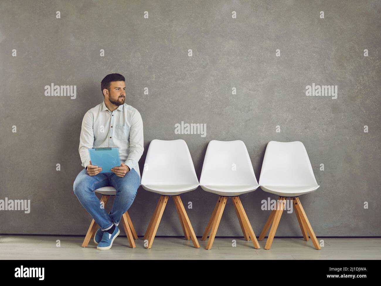 Job seeker candidato vacante in attesa di intervista guardando da parte sedersi su sedia Foto Stock