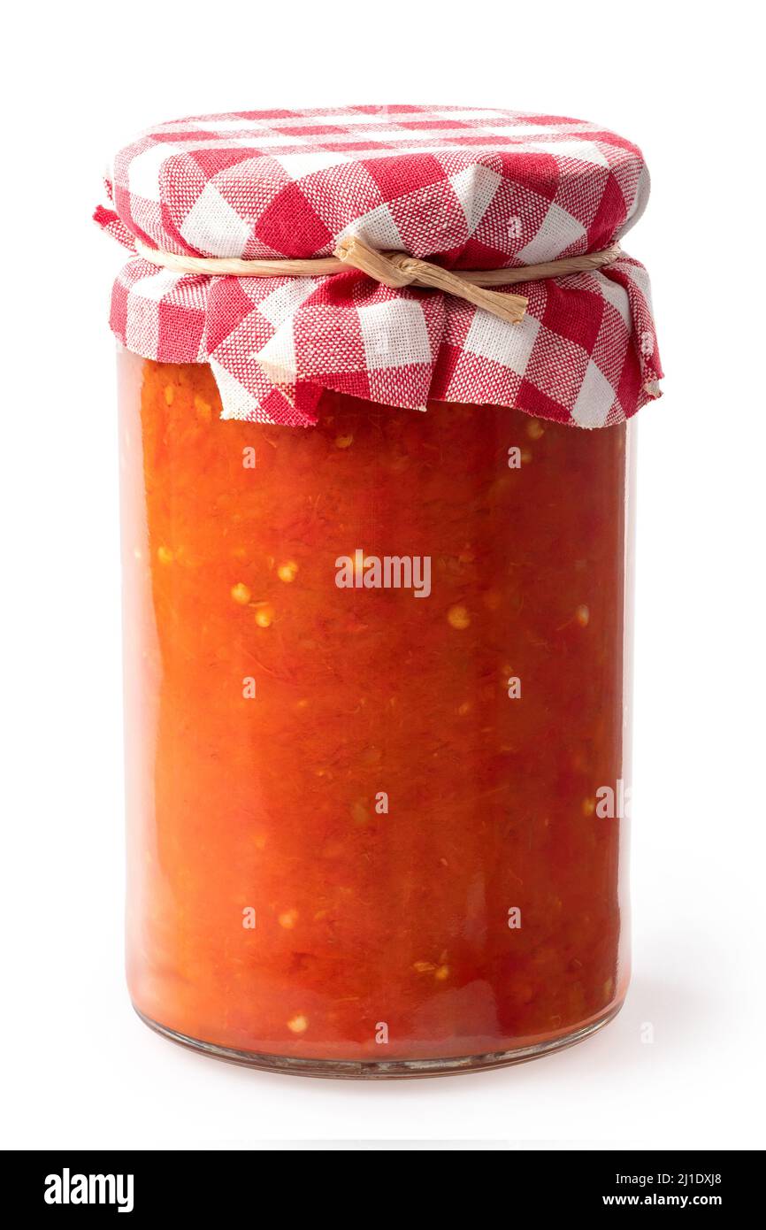 Ajvar in un vaso di vetro chiuso isolato su bianco. Tessuto scacchi con una corda. Foto Stock