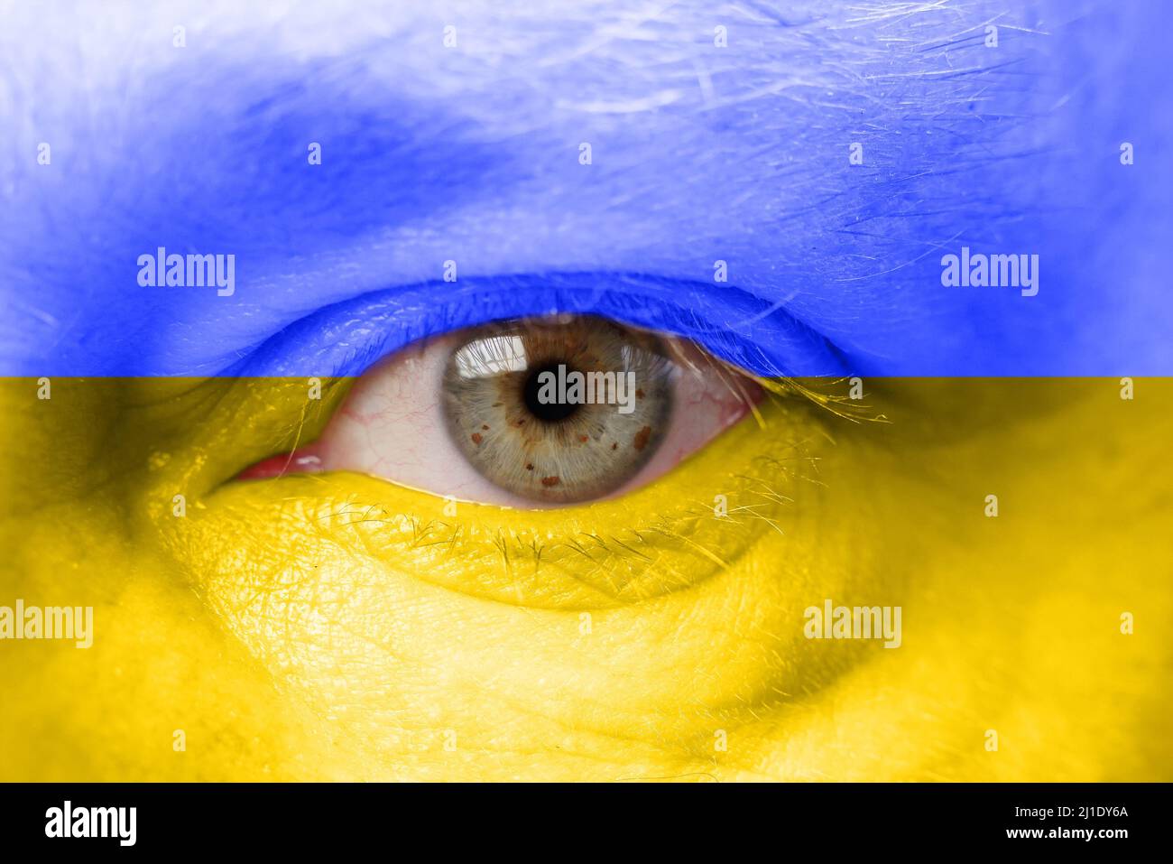 Concetto, volto di una persona nei colori della bandiera dell'Ucraina. Primo piano degli occhi Foto Stock