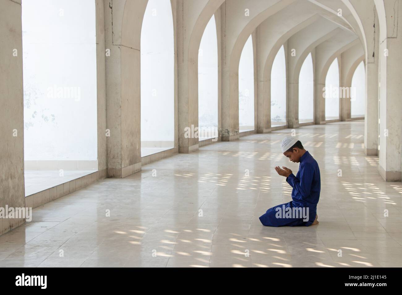 Dhaka, Dhaka, Bangladesh. 25th Mar 2022. Un bambino prega alla Moschea Nazionale di Baiitul Mukarram a Dhaka, Bangladesh. La Moschea Nazionale del Bangladesh, conosciuta come Baitul Mukarram o la Casa Santa in inglese, è una delle 10 moschee più grandi del mondo e può ospitare fino a 40.000 persone, anche nello spazio aperto esterno. La moschea ha diverse caratteristiche architettoniche moderne e allo stesso tempo conserva i principi tradizionali dell'architettura Mughal, che da qualche tempo è stata dominante nel subcontinente indiano. (Credit Image: © Joy Saha/ZUMA Press Wire) Credit: ZUMA Press, Inc./ Foto Stock