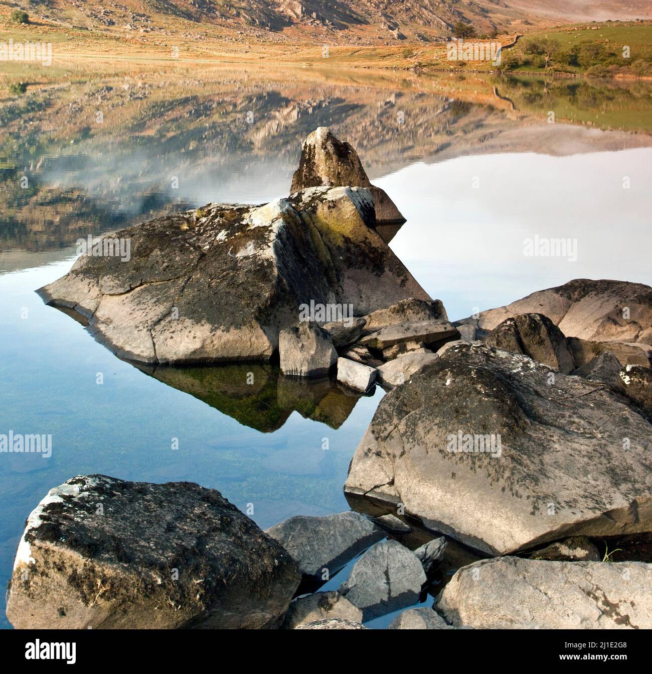 Spiaggia rocciosa Llyn Mymbyr Capel Curig, Parco Nazionale di Snowdonia Gwynedd North Wales UK, tarda primavera. Foto Stock
